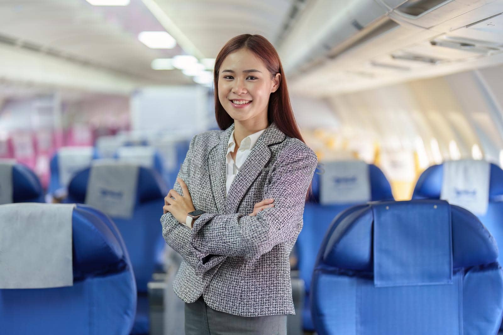 Portrait of a young Asian businesswoman smiling while riding a plane.