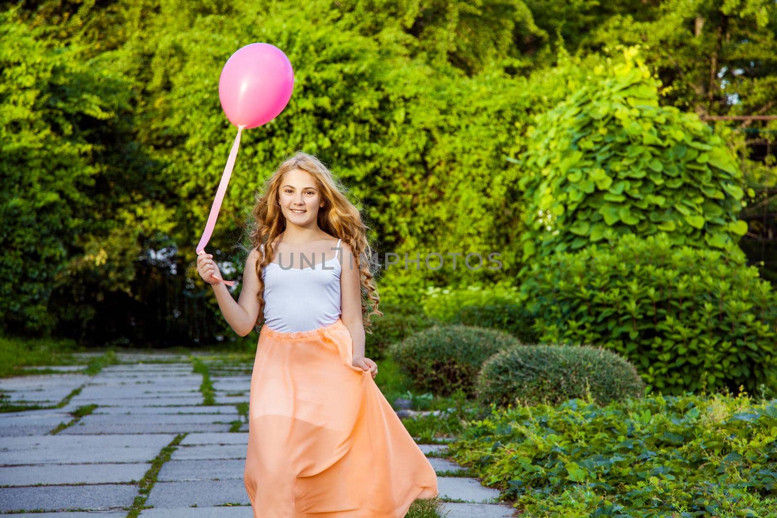 Portrait of happy girl with air balloon enjoying in the park on summertime.