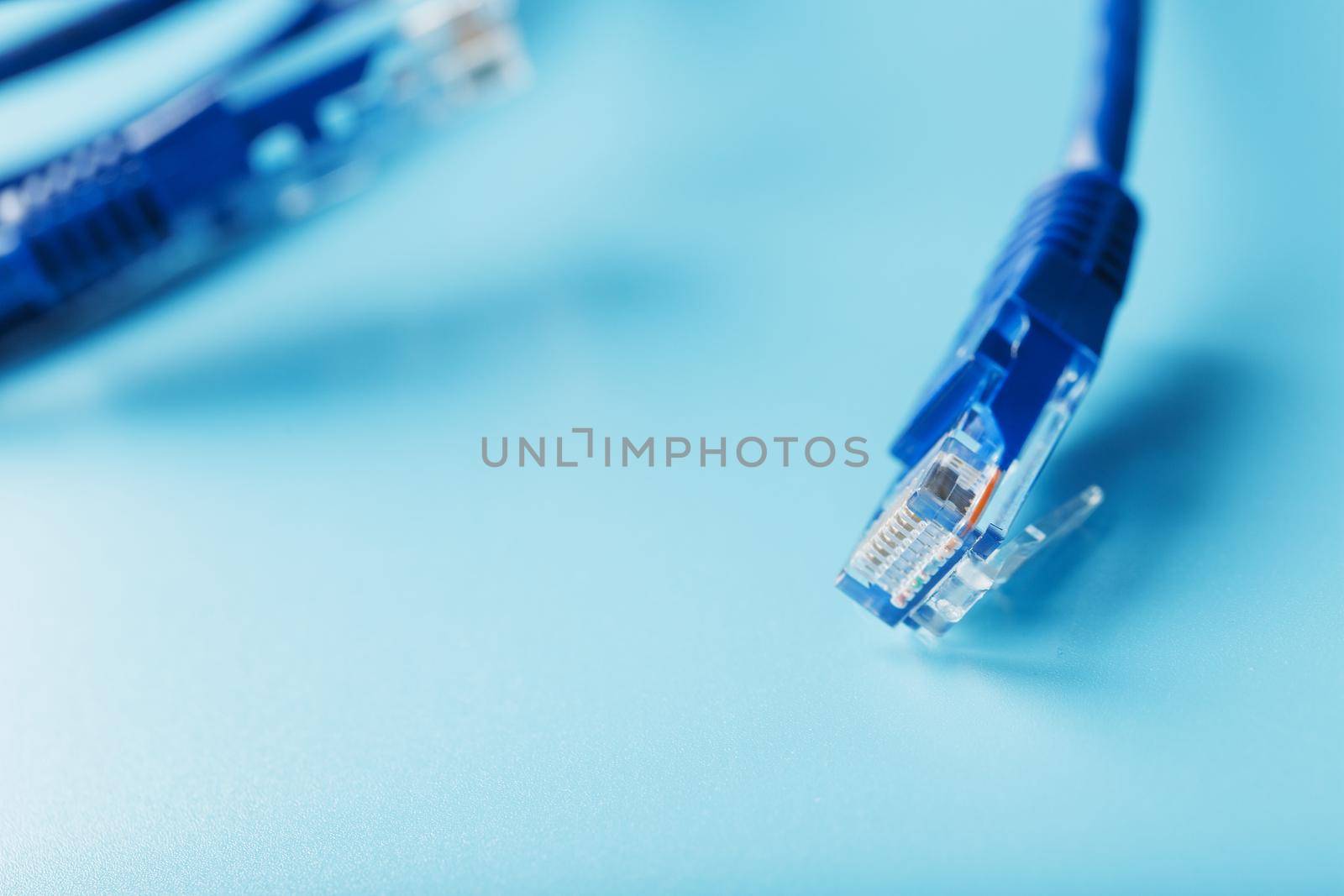 Blue UTP Internet Cable Isolated on a blue background Ethernet Cord by AlexGrec
