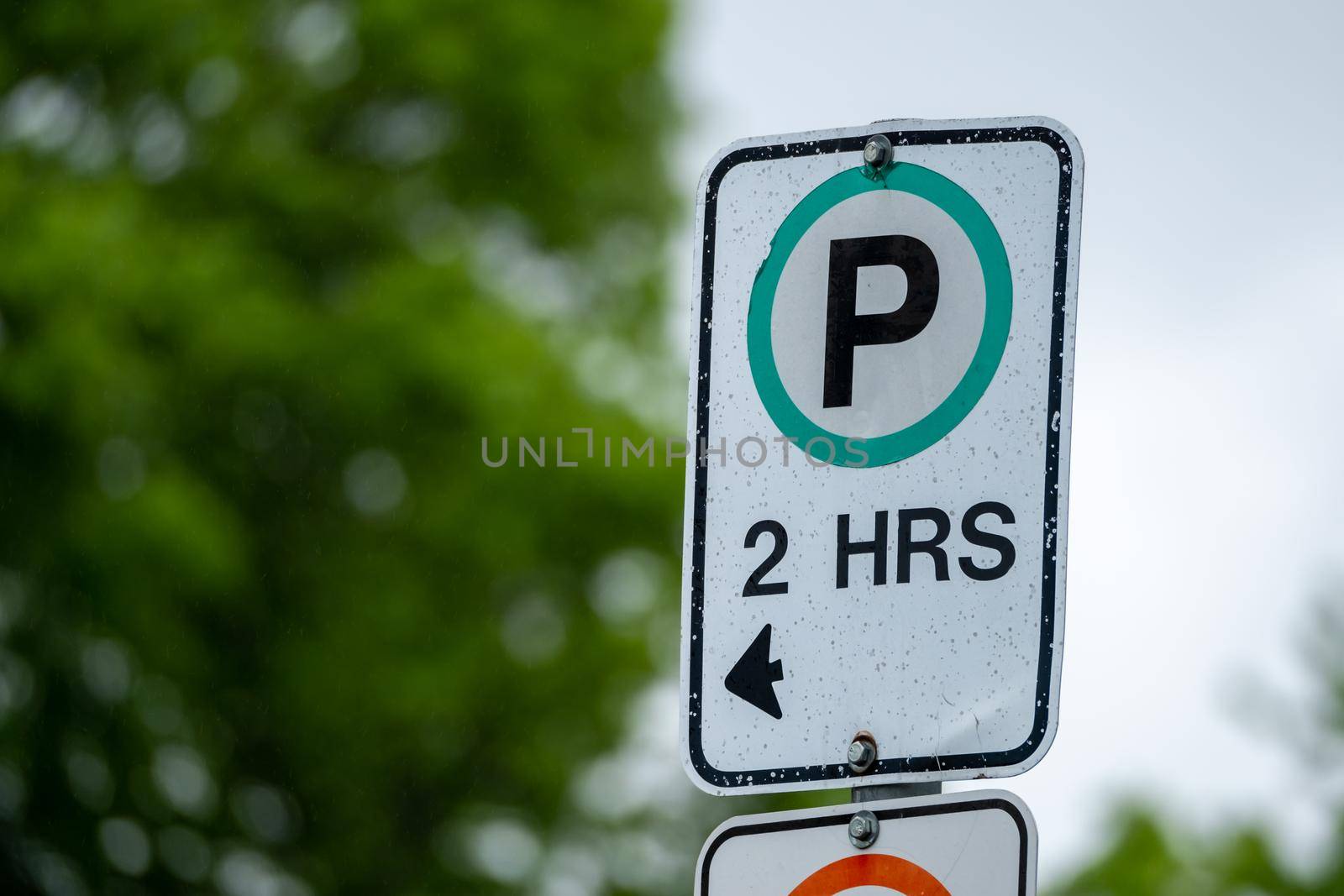 Close-up of a weathered metal sign designating parking spots with a two-hour limit