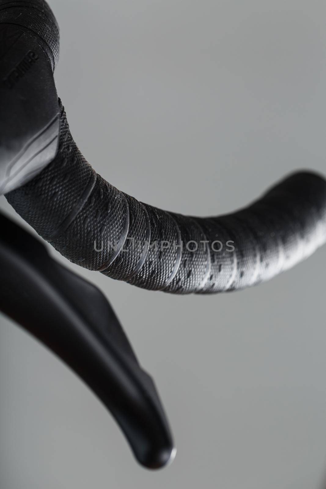 Steering wheel winding with brake handle of a road bike close-up on a gray background