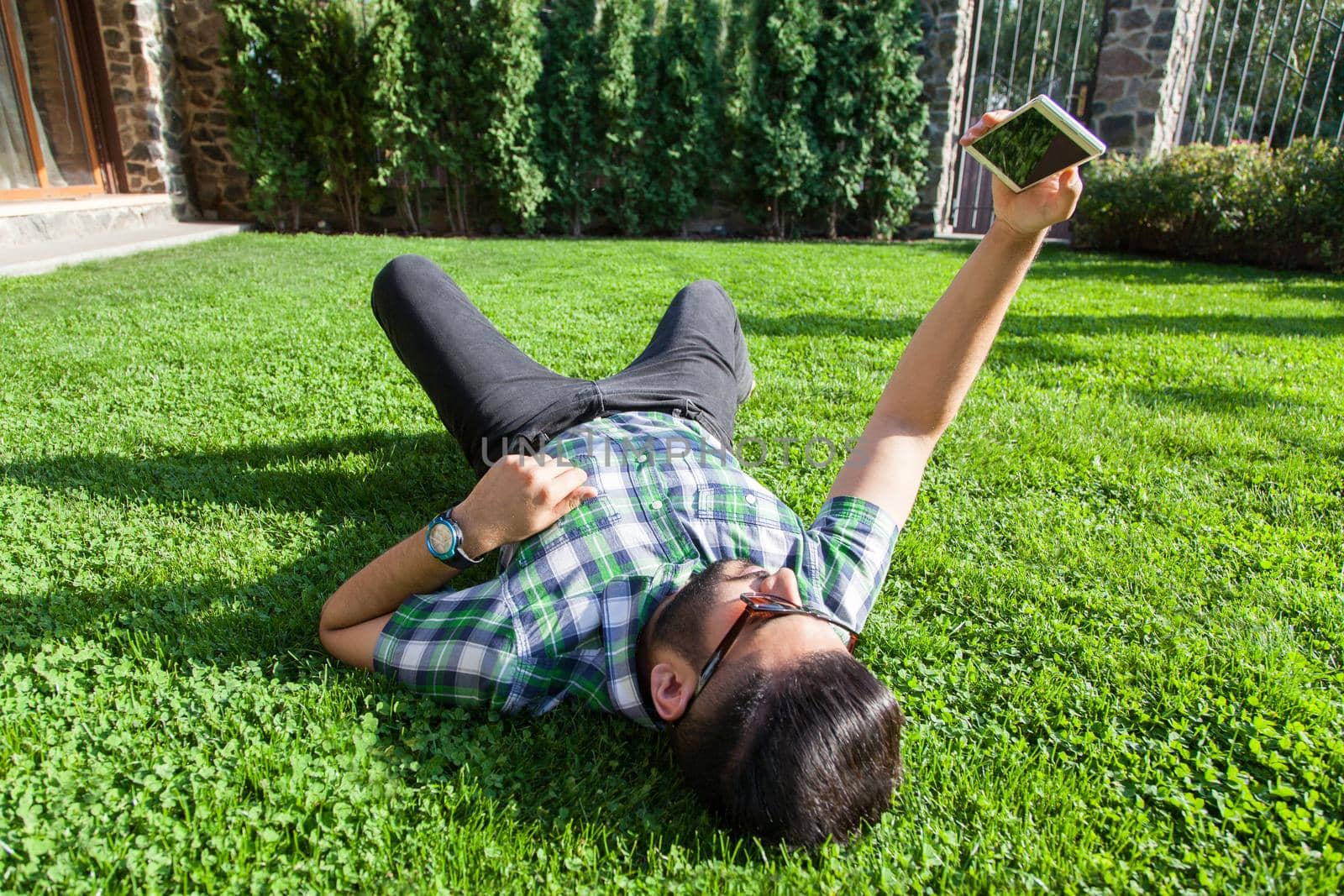 young man lie down on lawn and enjoying summertime.
