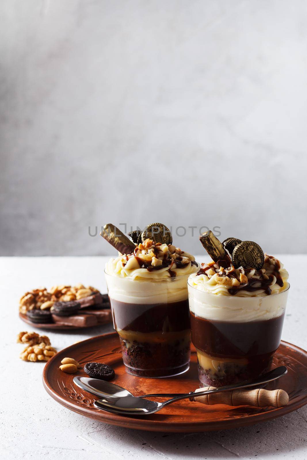 Delicious chocolate trifle or pudding with whipped cream in a glass on a gray background. copy space