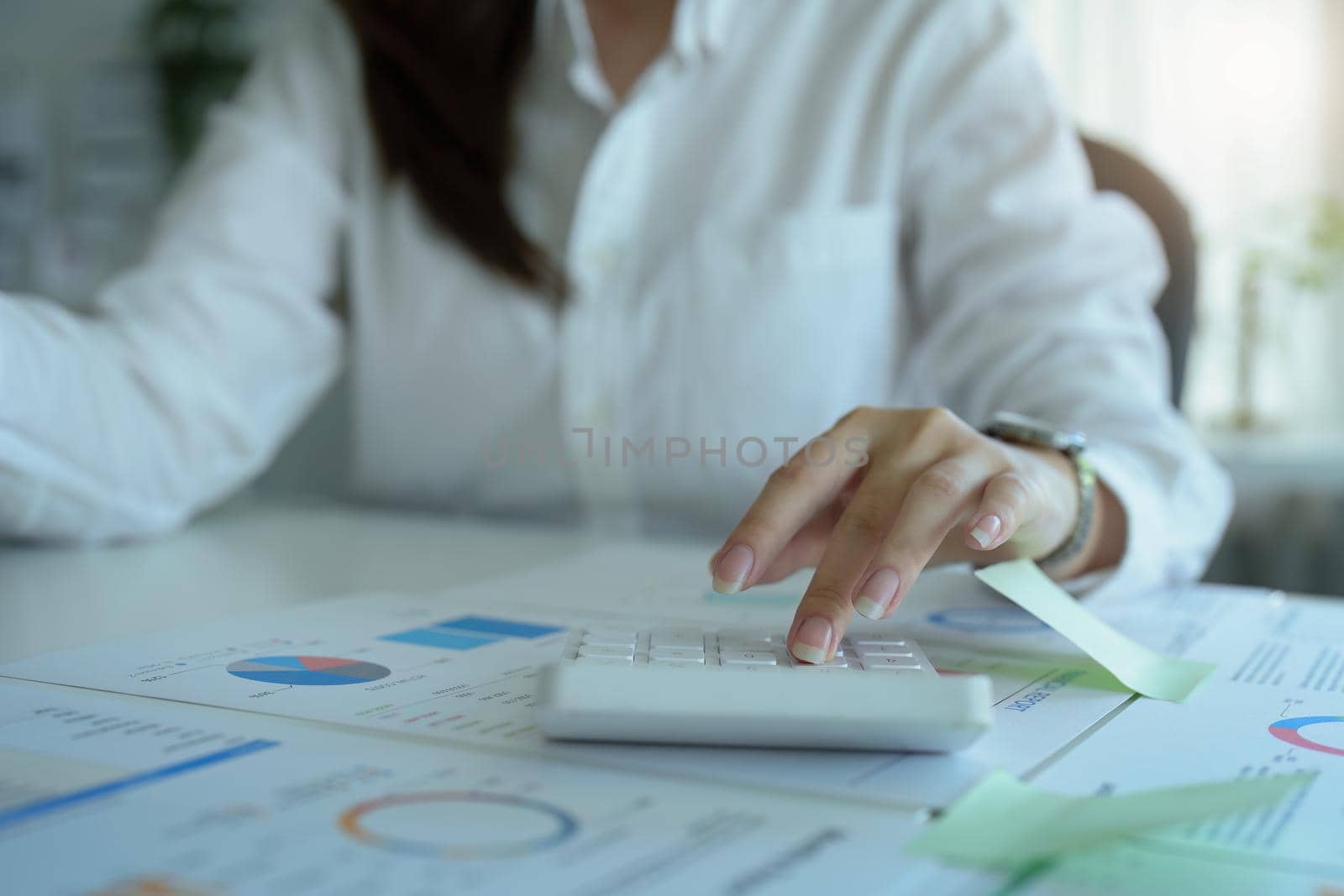 accountant, Auditor, Self-Employed, Finance and Investment, tax calculation and budget, Asian female entrepreneur using a calculator to calculate. Company business results document