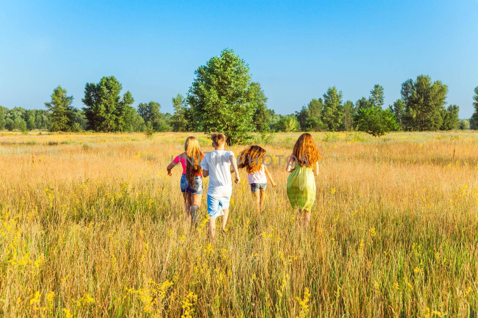 four happy beautiful children running playing moving together in the beautiful summer day. by Khosro1