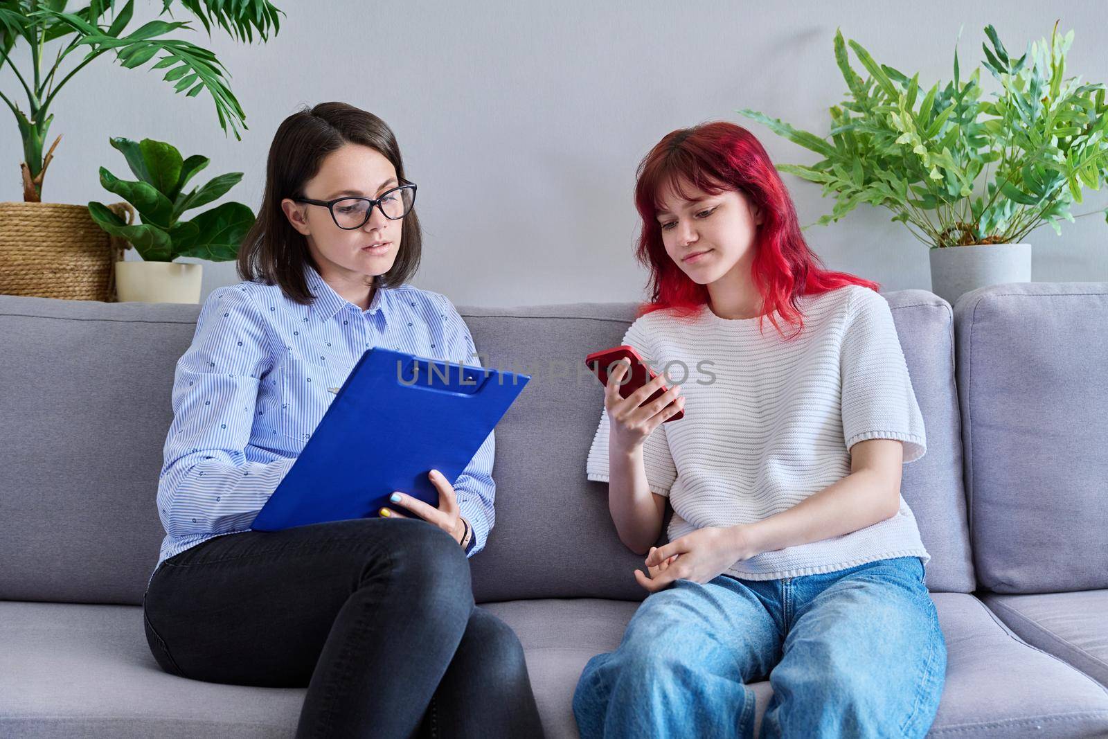 Psychologist counseling teenage female, individual therapy in doctors office. by VH-studio