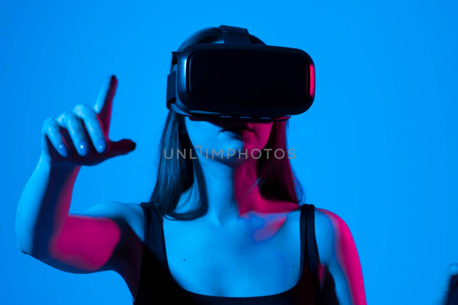 Amazed happy brunette girl in black t-shirt getting experience using VR headset glasses of virtual reality and exploring a new cyber worlds. by vovsht