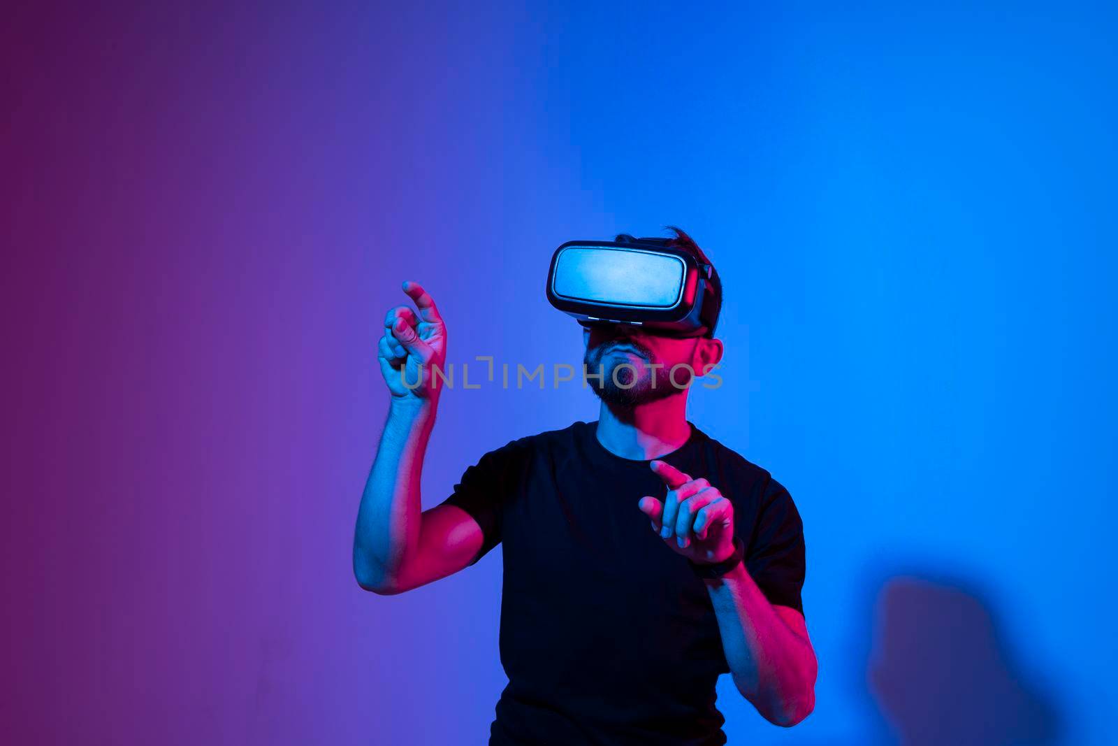 Modern architect, designer using virtual reality glasses at workplace. Designer working in augmented reality vr studio. Man working in VR goggles on a studio background