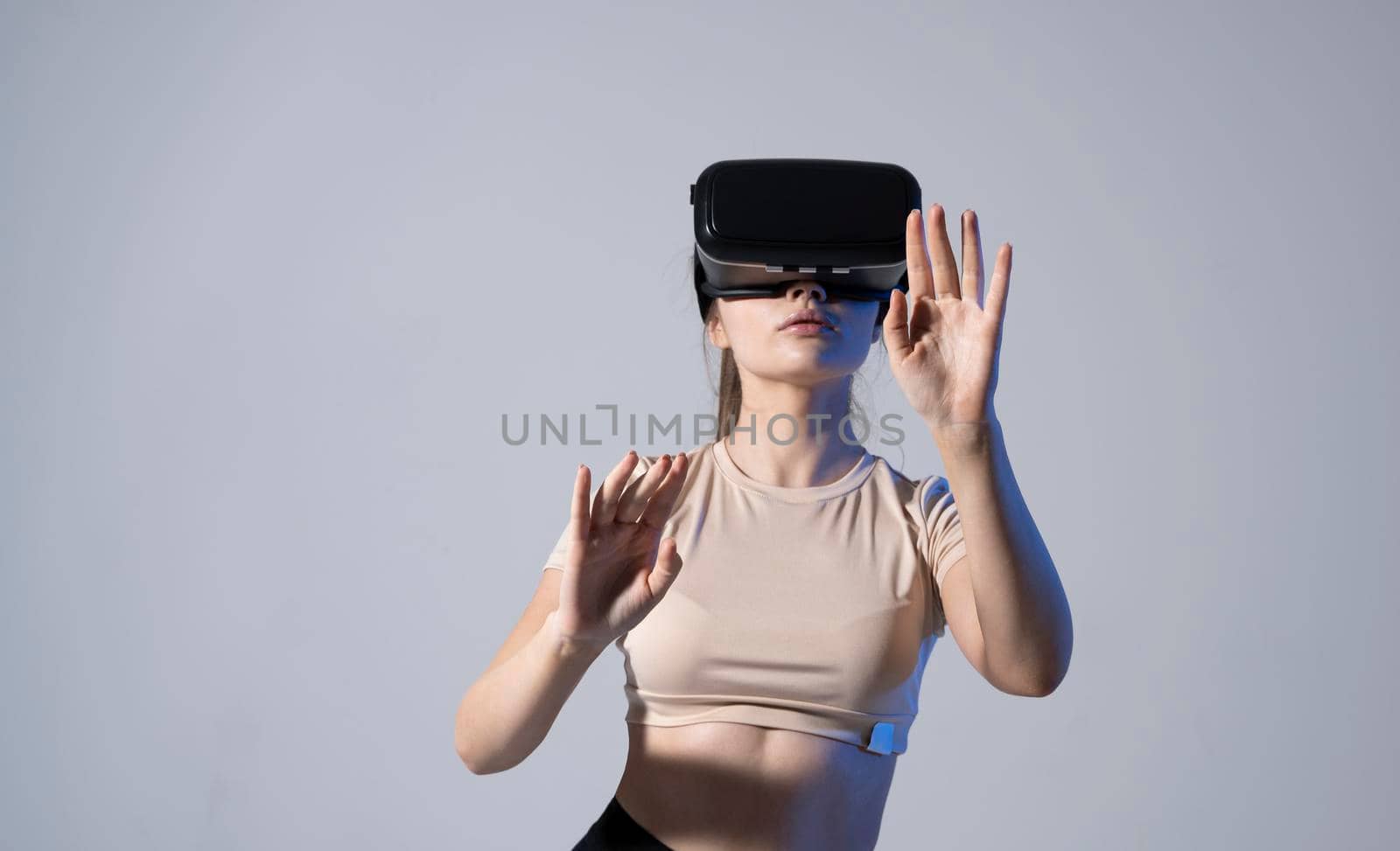 Young beautiful brunette woman wearing a VR headset and experiencing a virtual reality simulation, metaverse and cyberspace concept. Future technology concept