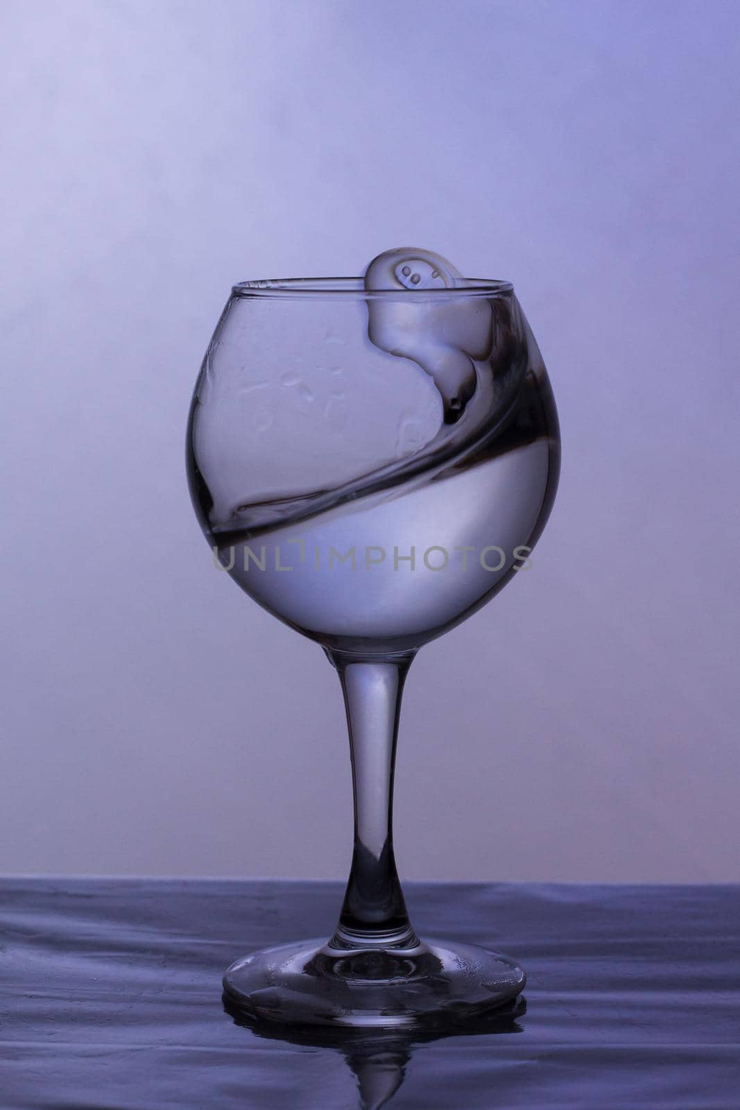 Splashes of water from a glass in the shape of a tulip on a white background. Very Peri