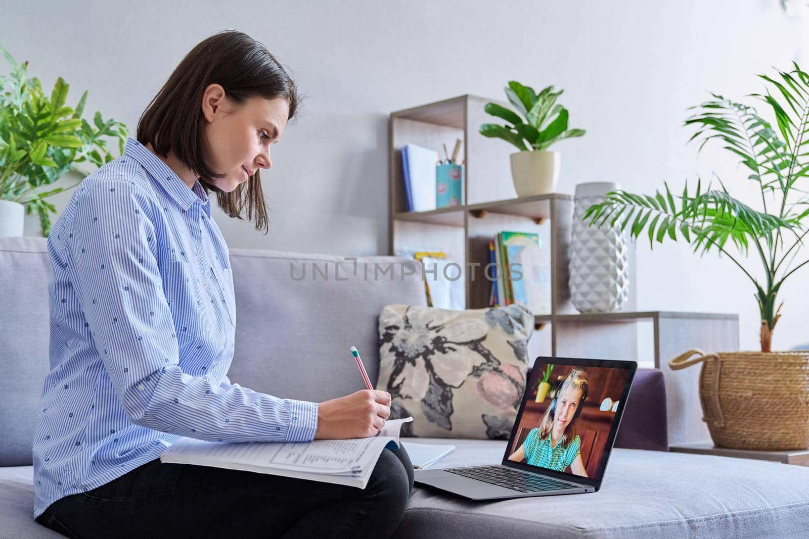Young female teacher making video conference for child girl sitting in home office. Online meeting of student and teacher, e-learning, remote distance lesson. School, technology, teaching, knowledge