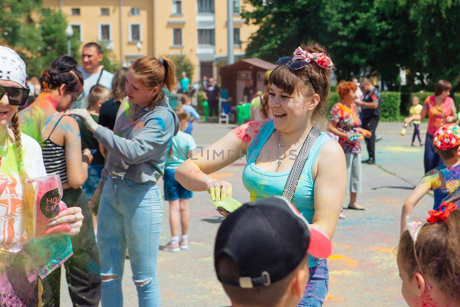 Novokuznetsk, Kemerovo region, Russia - June 12, 2022 :: Woman with colorful face painted with holi powder having fun outdoors.