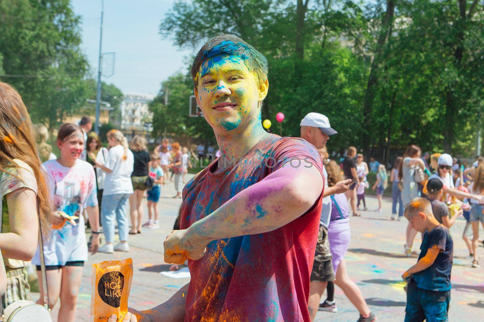 Novokuznetsk, Kemerovo region, Russia - June 12, 2022 :: Boy with colorful face painted with holi powder having fun outdoors.