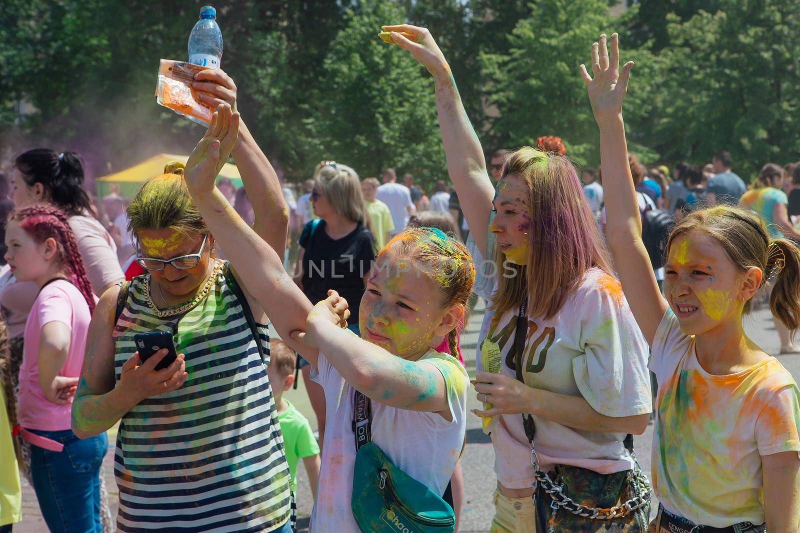 Novokuznetsk, Kemerovo region, Russia - June 12, 2022 :: Children with colorful faces painted with holi powder having fun outdoors.