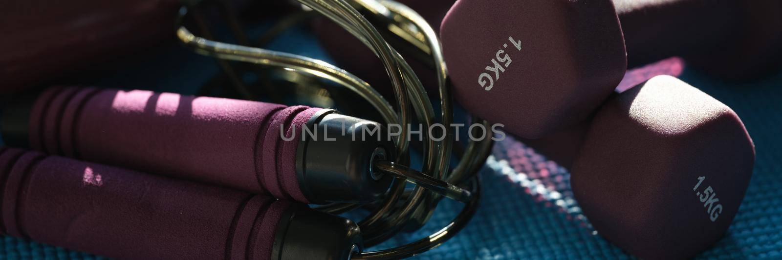 Lilac dumbbells skipping rope set for fitness, close-up by kuprevich