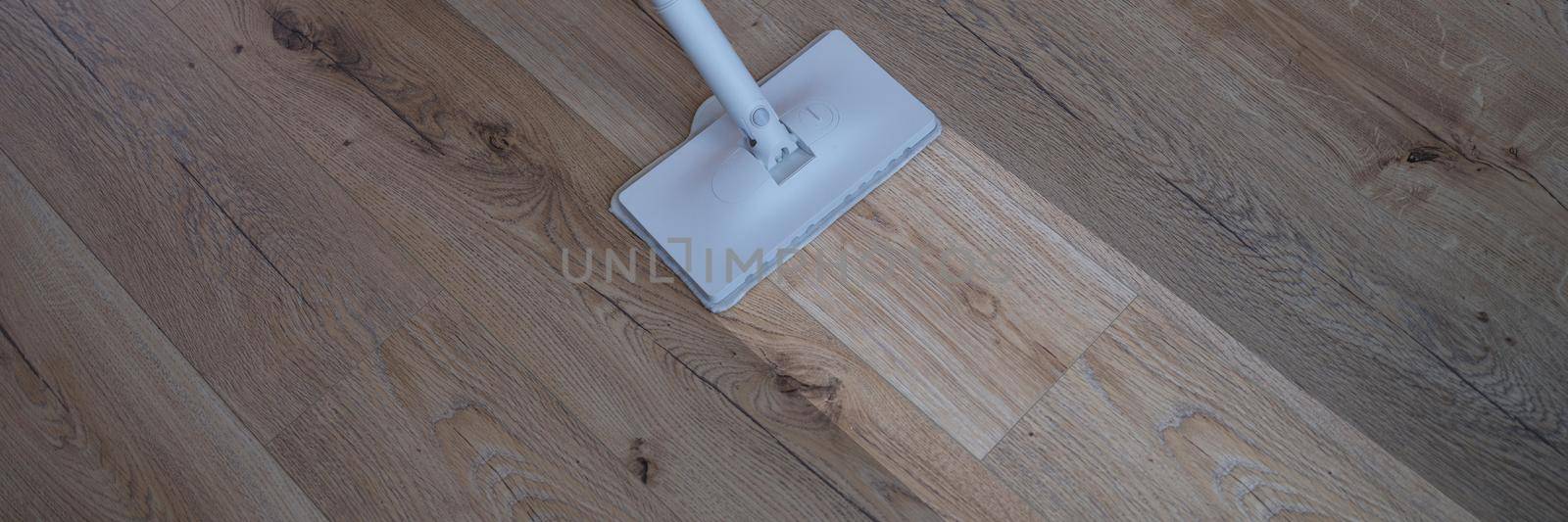 A washing vacuum cleaner washes the laminate, a clean footprint on the floor, close-up. Parquet cleaning equipment