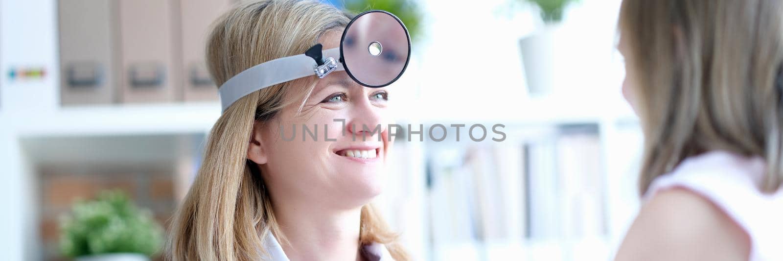 Female doctor at the clinic smiling at the girl by kuprevich