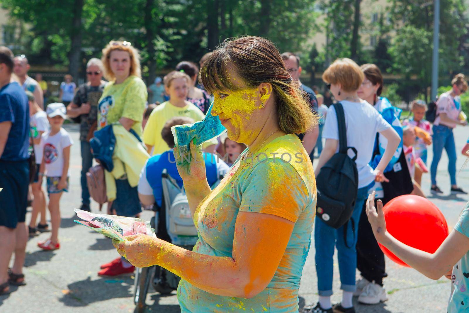 Novokuznetsk, Kemerovo region, Russia - June 12, 2022 :: Woman with colorful face painted with holi powder having fun outdoors.