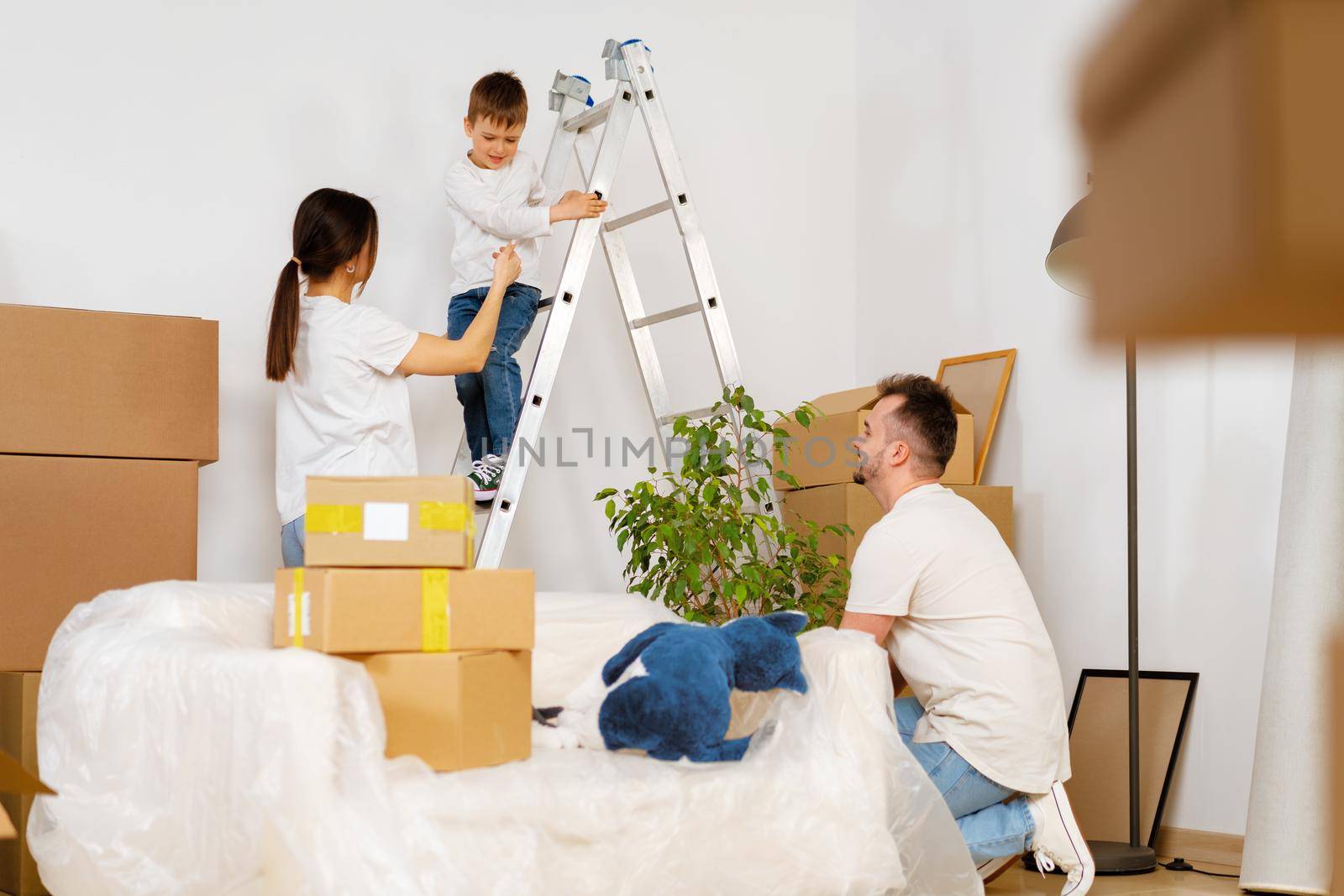 Portrait of happy family with cardboard boxes in new house at moving day, close up