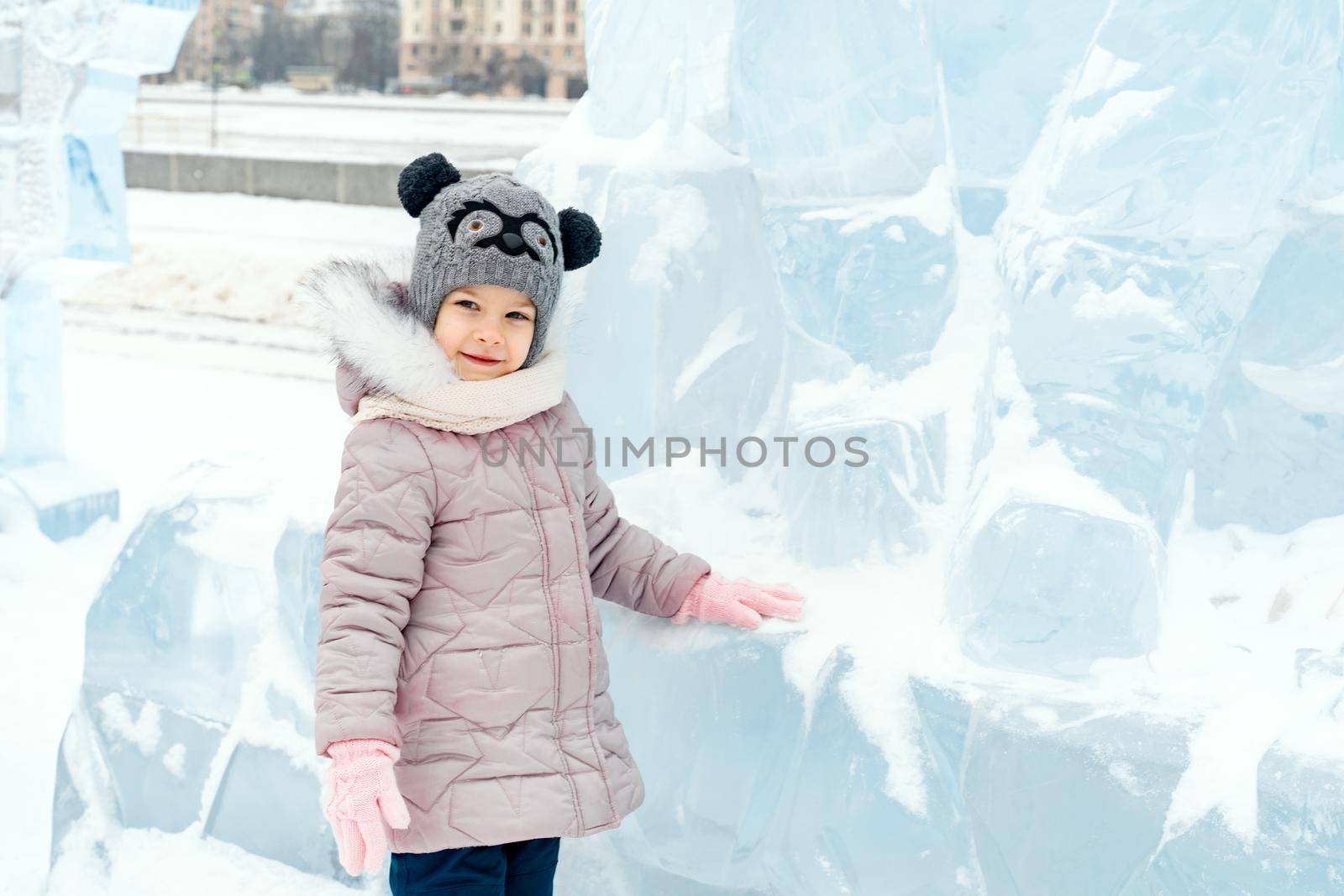 playful child girl happy in snow town on winter day