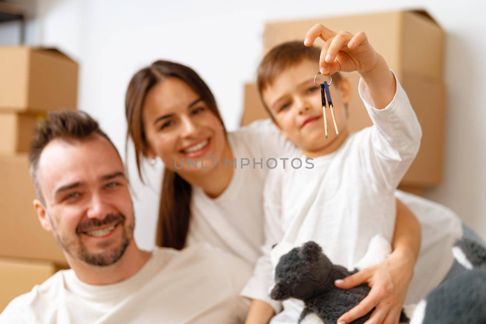 Portrait of happy family with cardboard boxes in new house at moving day, close up