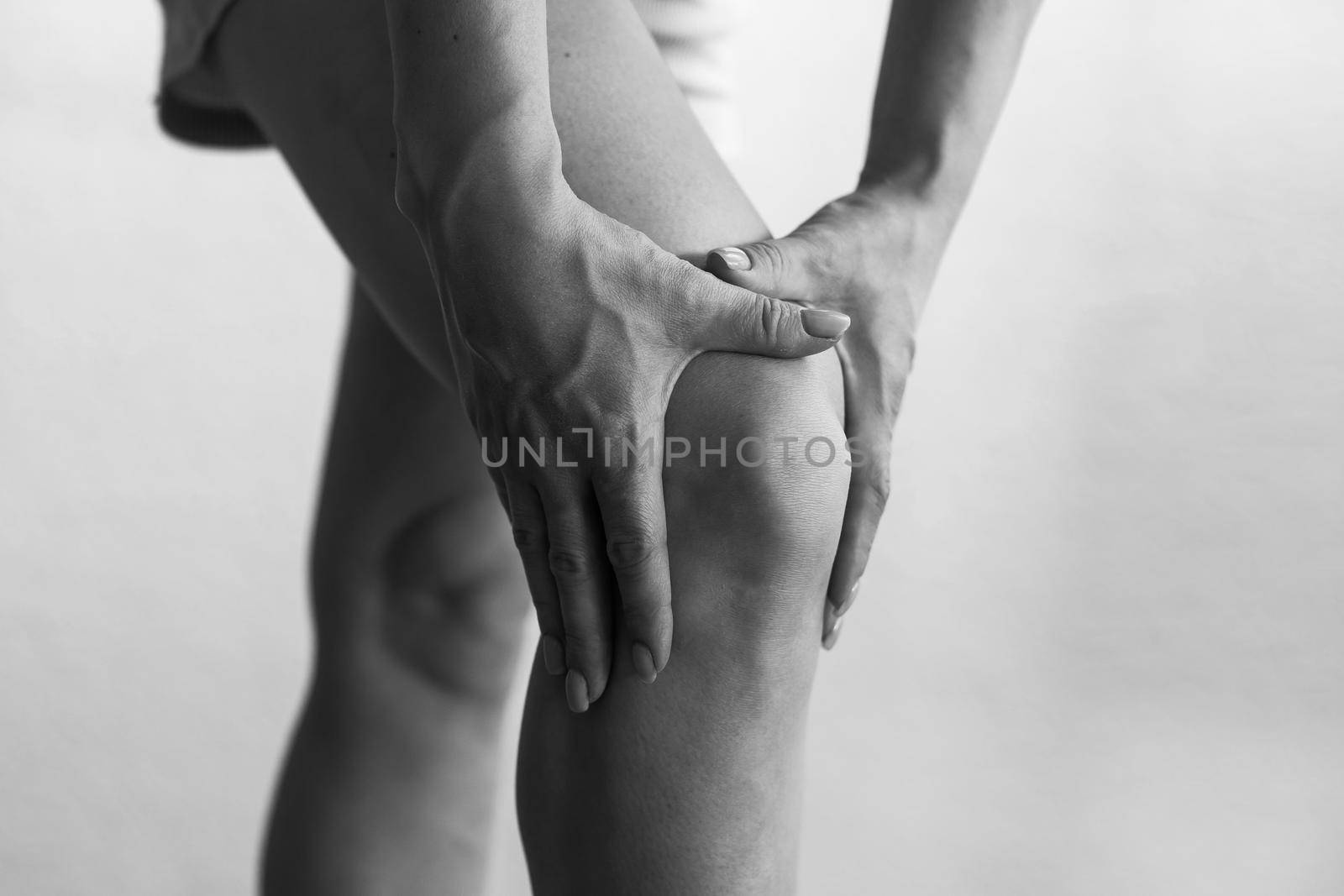 Closeup woman hand hold knee with pain symptom, health care and medical concept.