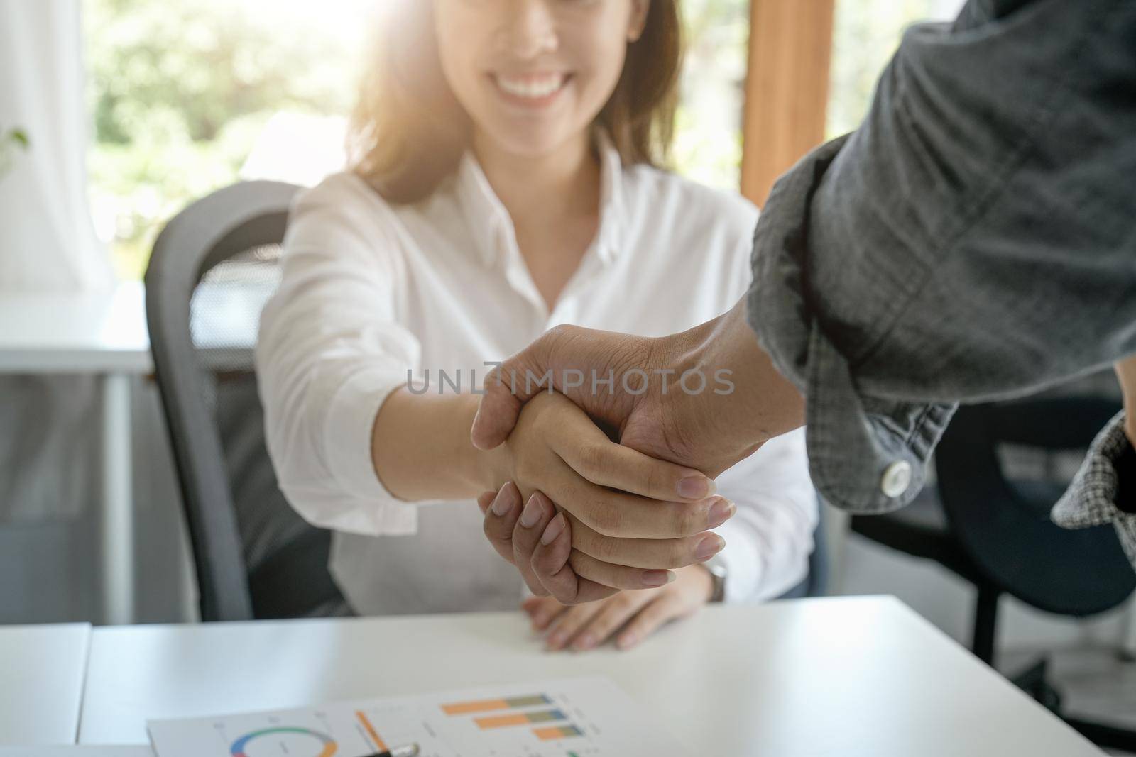 Happy asian businesswoman doing a handshake. finishing up meeting, business etiquette, congratulation, merger and acquisition concept by nateemee