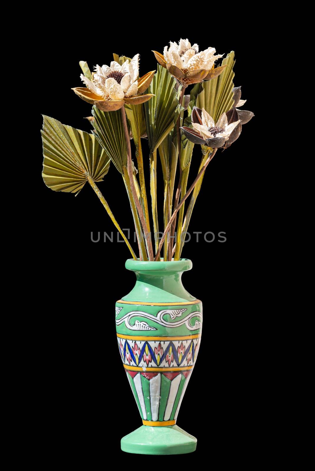 Green vase with colored decoration, with flowers, isolated on black background