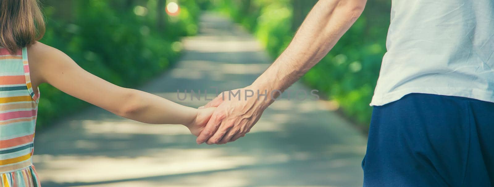 Father and child go holding hand. Selective focus. nature.