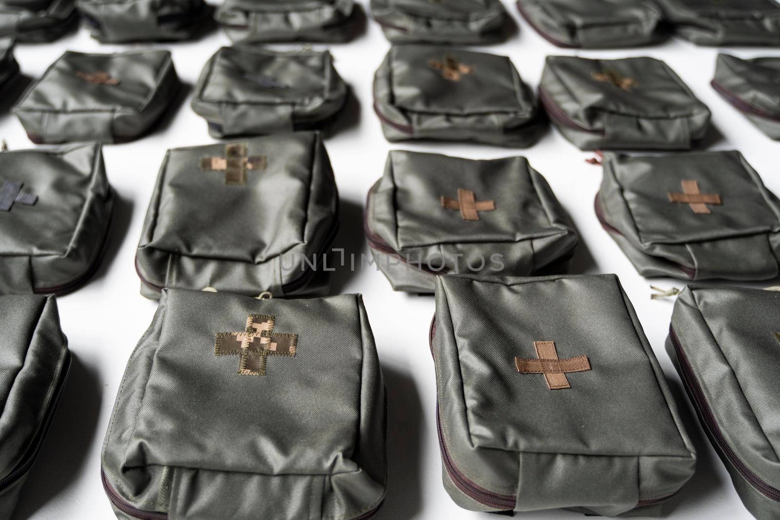 A lot of army first aid kits on white background