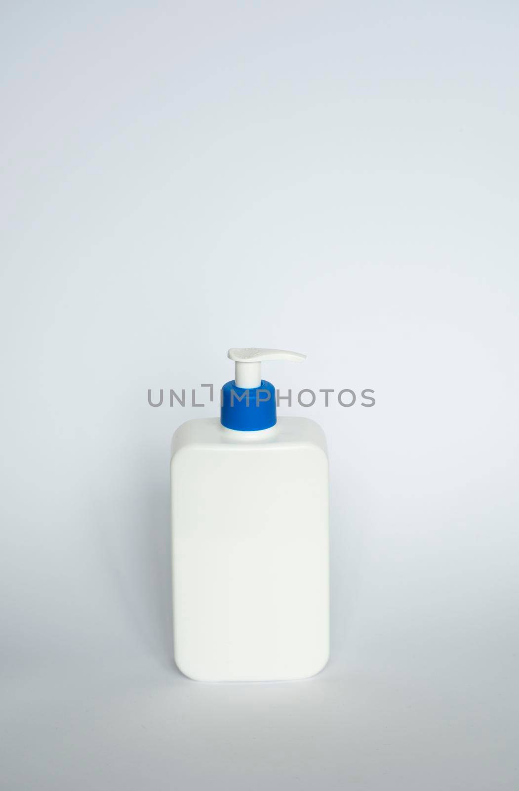 Large white cosmetic plastic bottle with pump dispenser pump and blue cap on white background. Liquid container for gel, lotion, cream, shampoo, bath foam. by vovsht