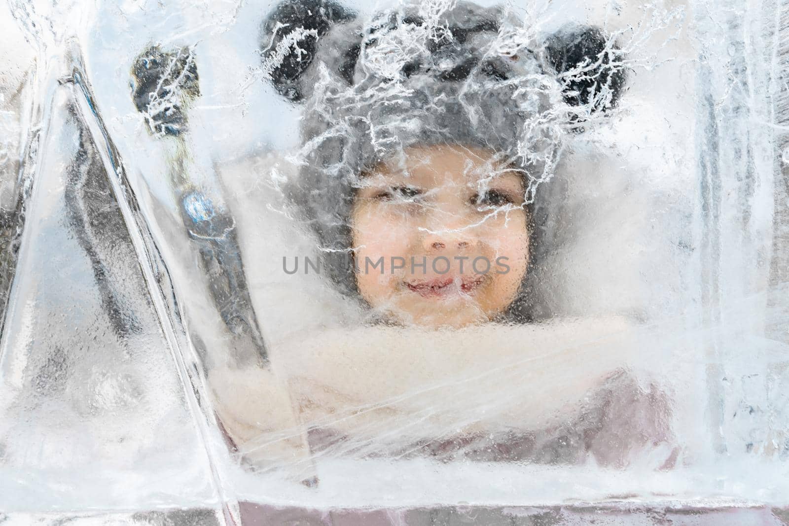 a child smiling while looking at a large ice floe by Lena_Ogurtsova