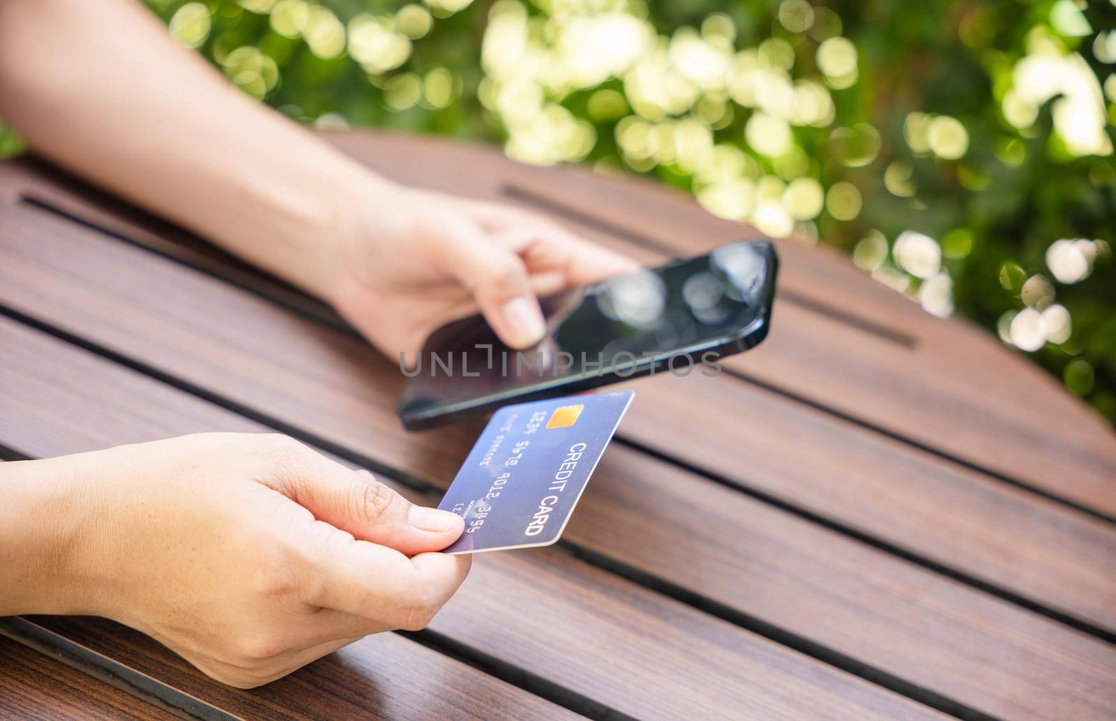 Close up hand of woman using credit card and smartphone during slide screen for finding product purchase buying payments online shopping, making secure internet payment browsing banking service