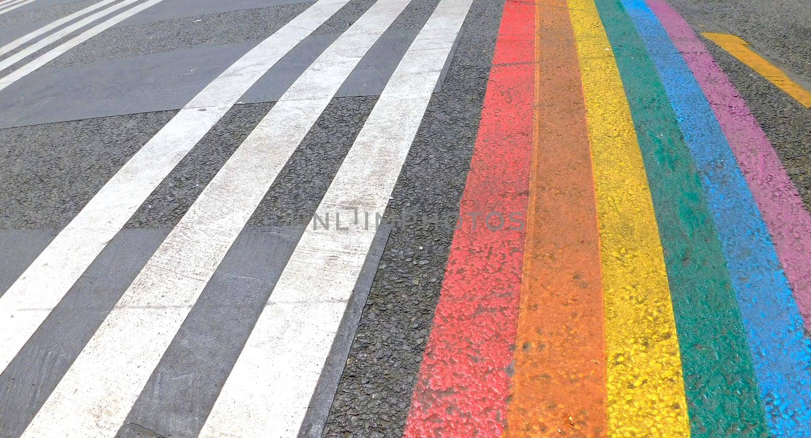 Marked crosswalk with lbgtq pride flag rainbow stripes. Colored chalk