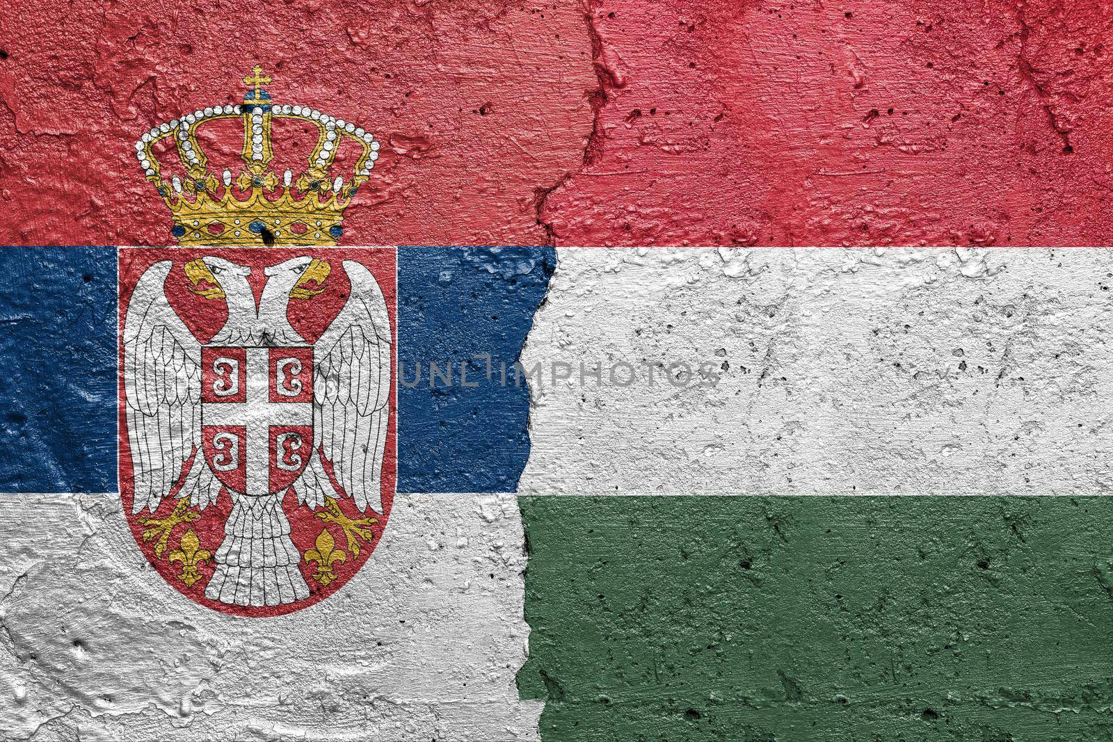 Serbia and Hungary - Cracked concrete wall painted with a Serbian flag on the left and a Hungarian flag on the right stock photo by adamr