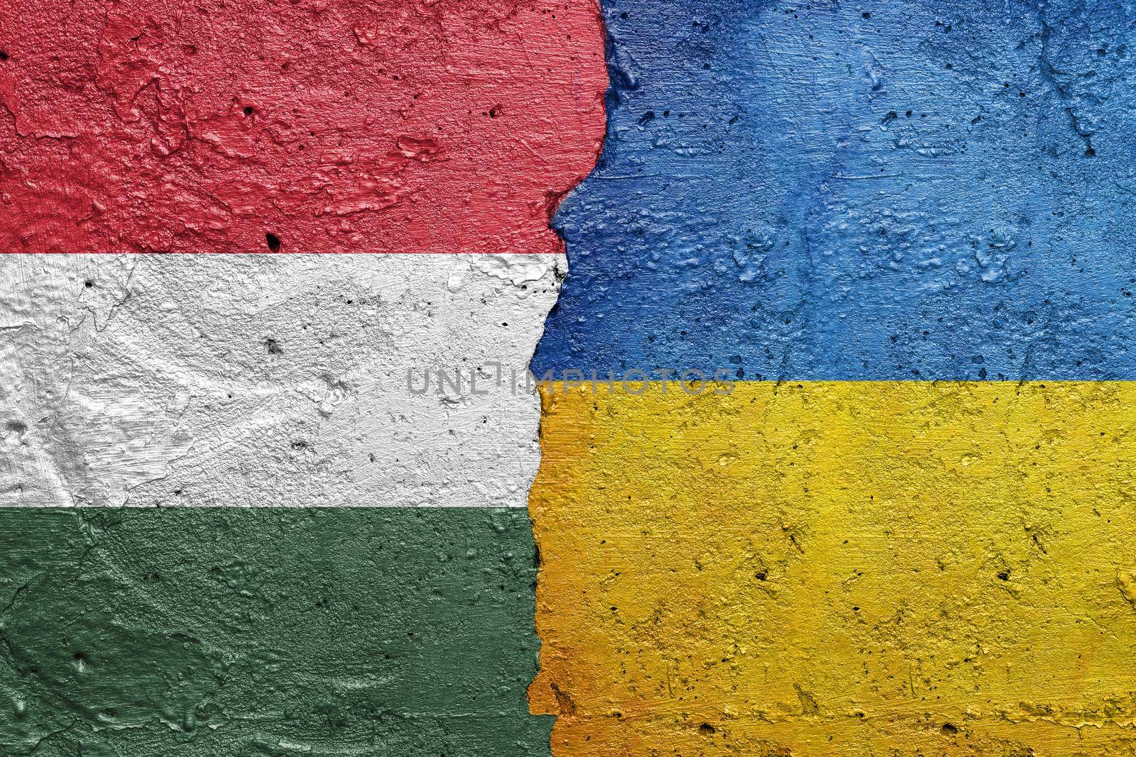 Hungary and Ukraine - Cracked concrete wall painted with a Hungarian flag on the left and a Ukrainian flag on the right