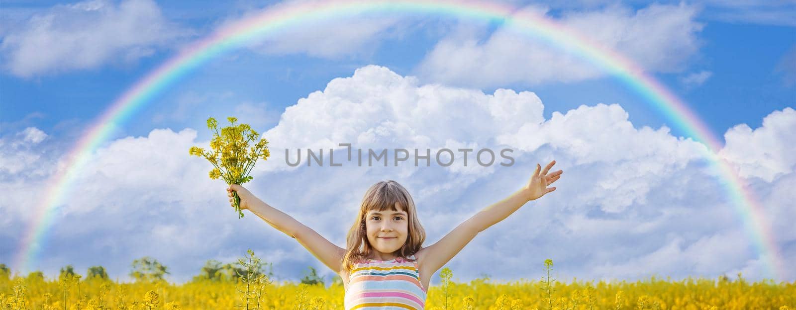A child in a yellow rainbow field. Selective focus.