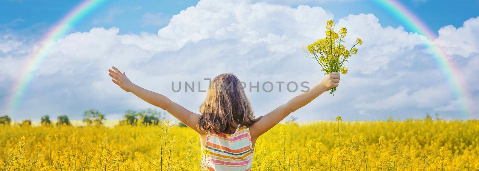A child in a yellow rainbow field. Selective focus. nature.