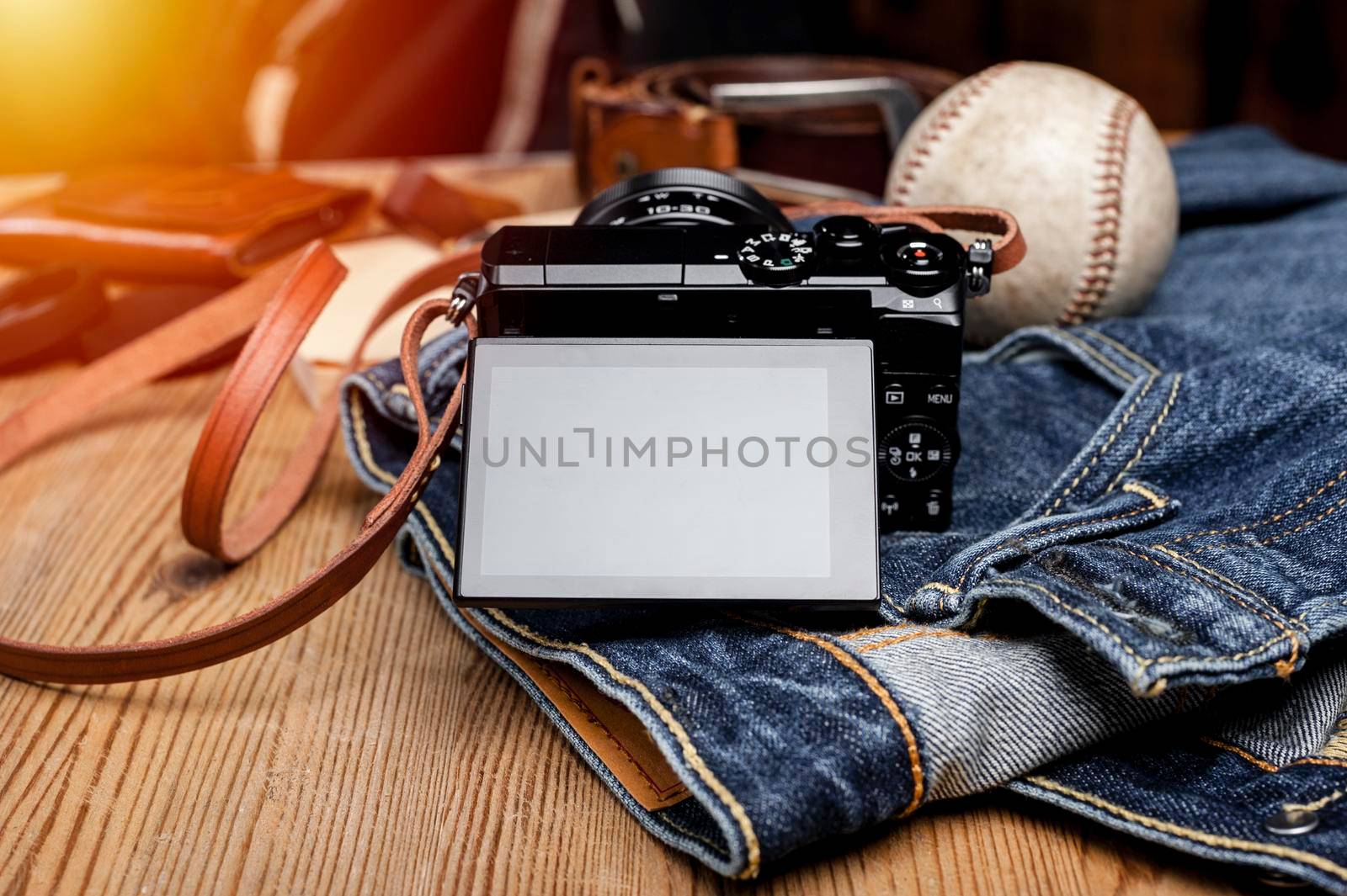 closeup blank screen of digital mirrorless camera with leather strap.