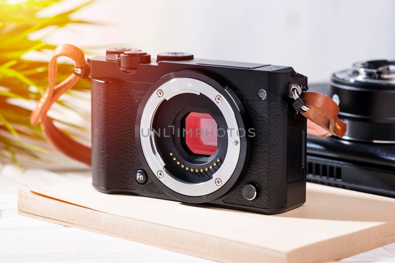 closeup vintage style of digital mirrorless camera with leather strap.