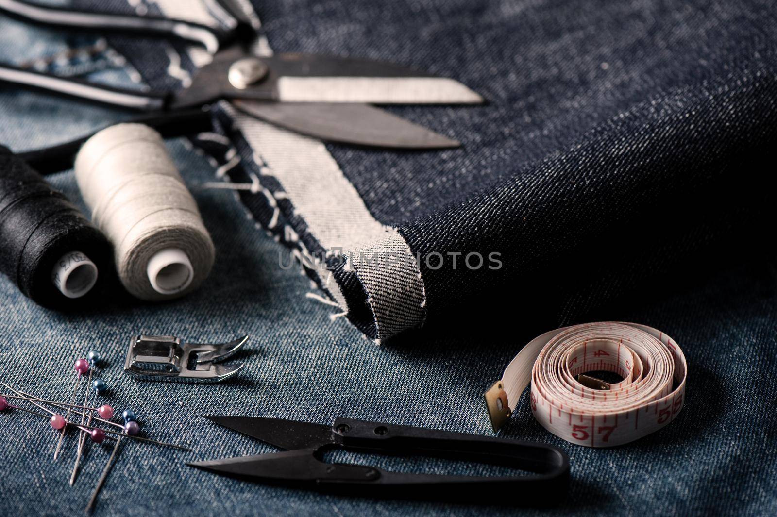 indigo denim fabric with sewing equipments, garment industrial concept.