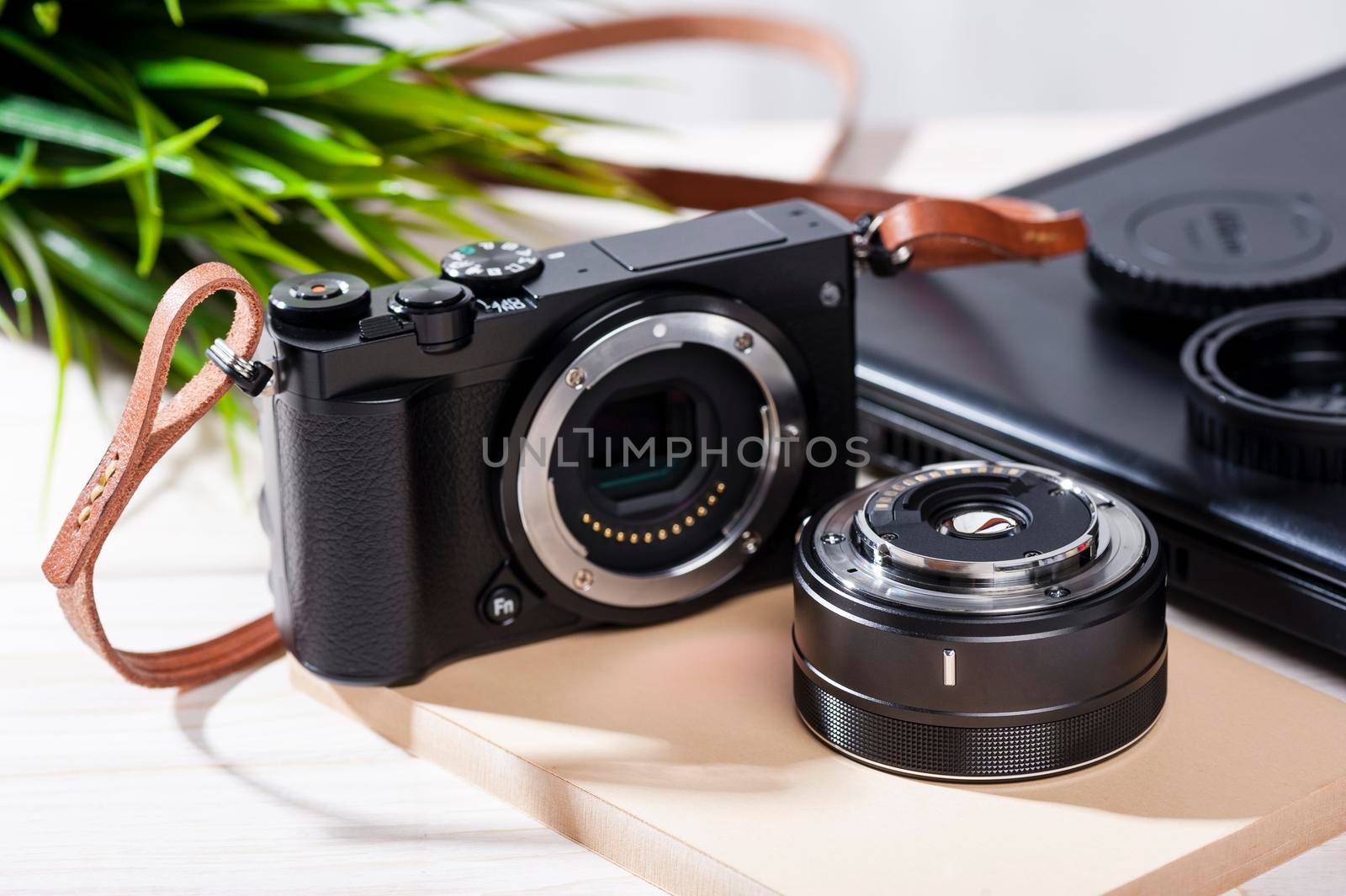 closeup vintage style of digital mirrorless camera with leather strap.