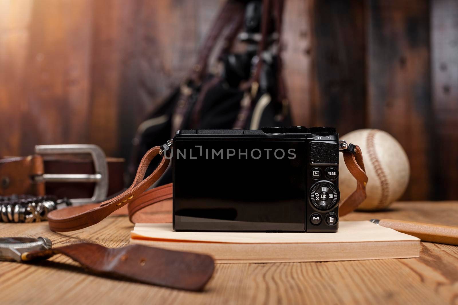 closeup blank screen of digital mirrorless camera with leather strap.