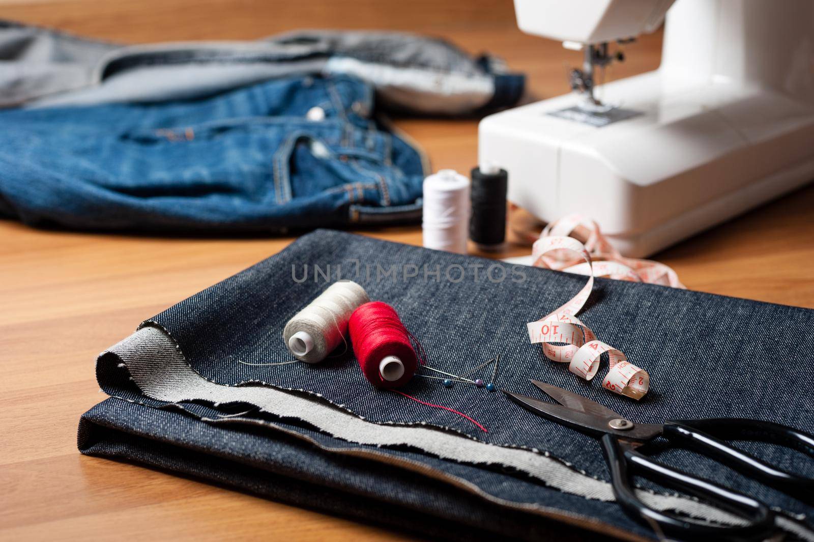 indigo denim fabric with thread and tools, garment industrial concept.