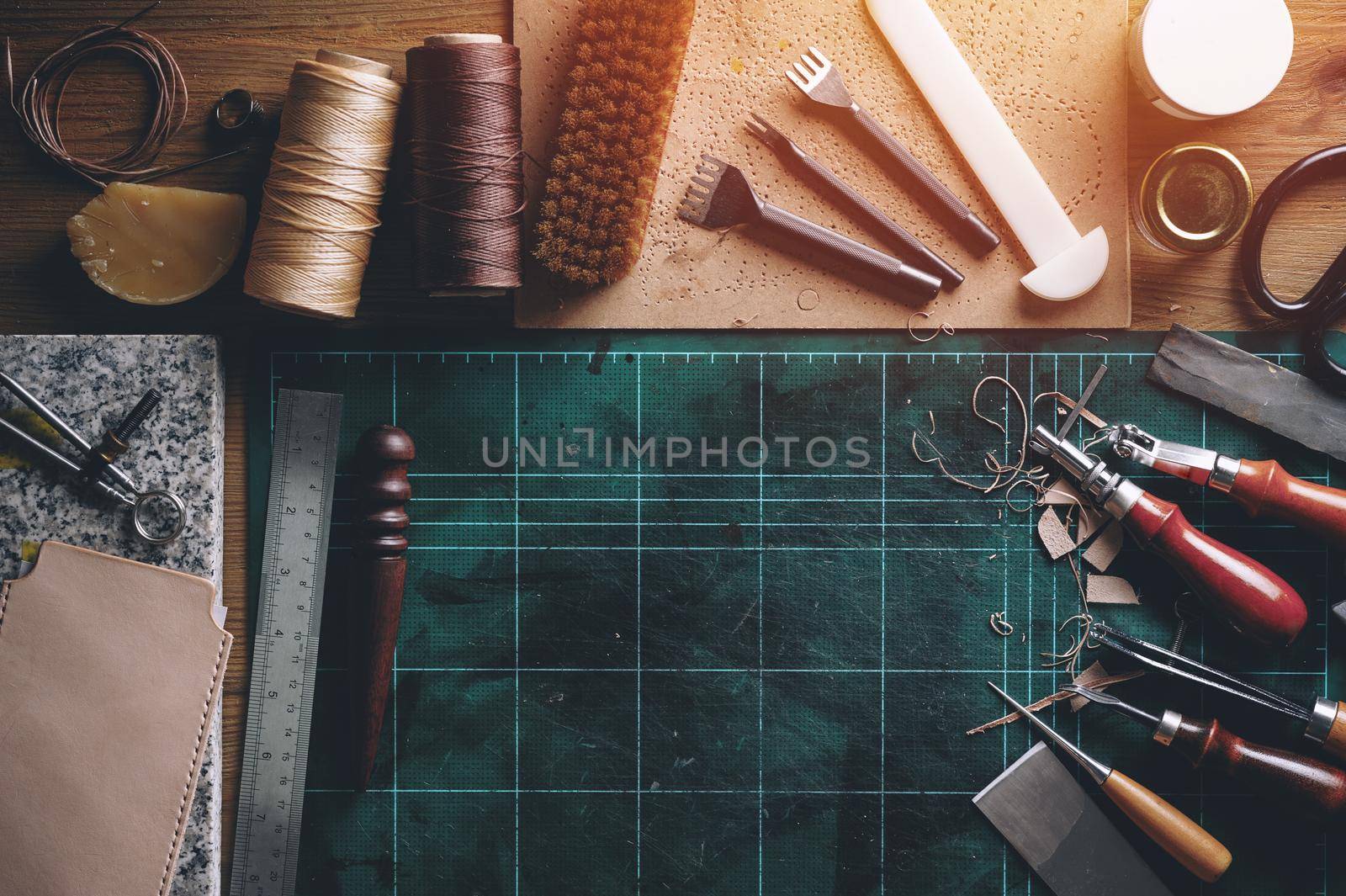 flat lay of leather working tools on wooden desk