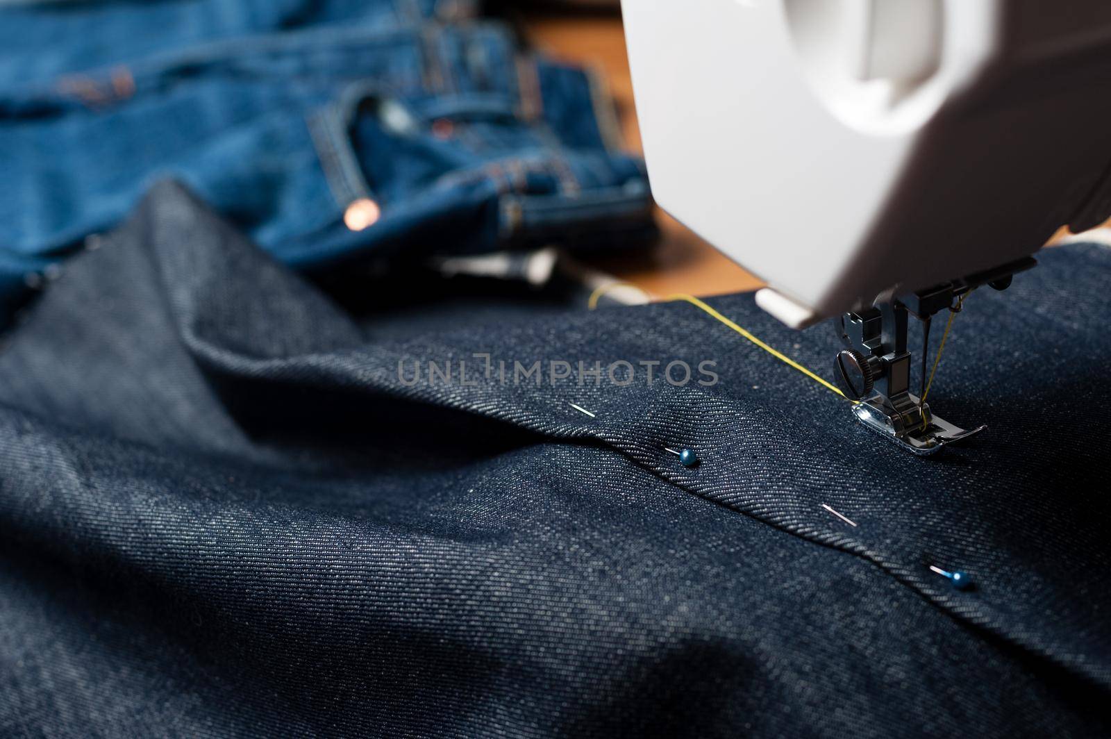 sewing indigo denim jeans with sewing machine, garment industrial concept.