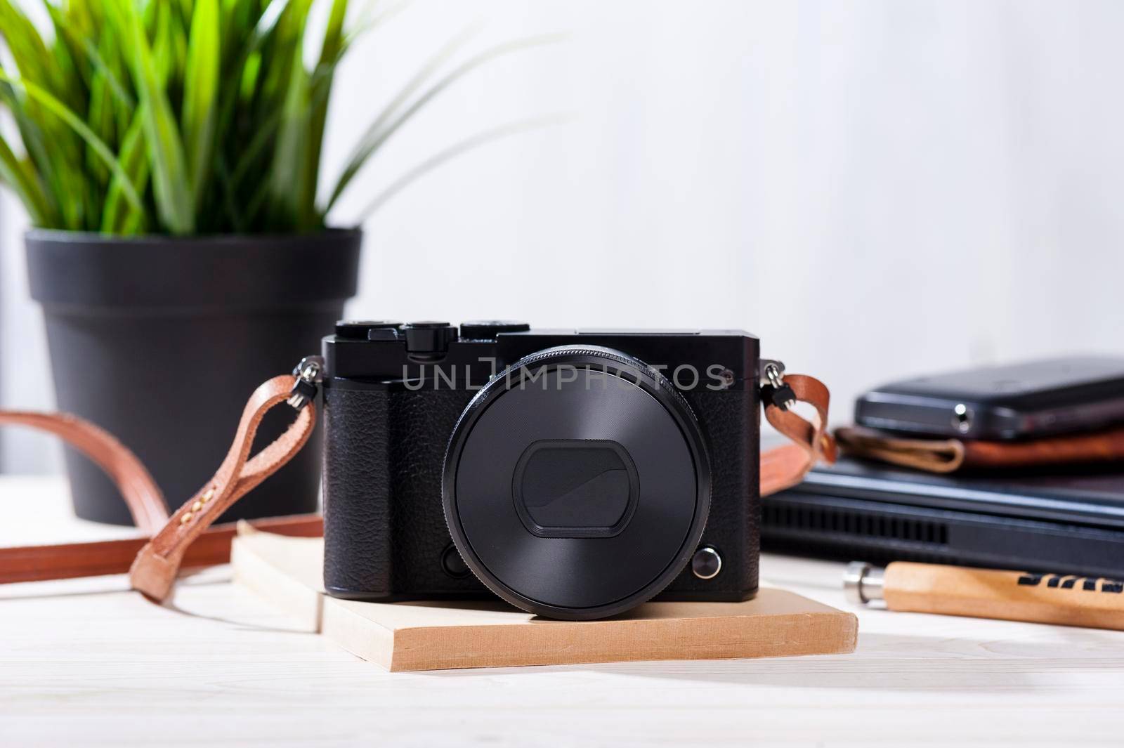 closeup vintage style of digital mirrorless camera with leather strap.