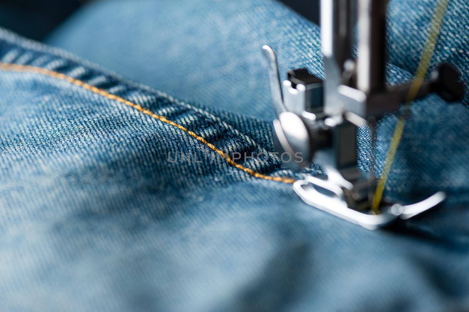 sewing indigo denim jeans with sewing machine, garment industrial concept.