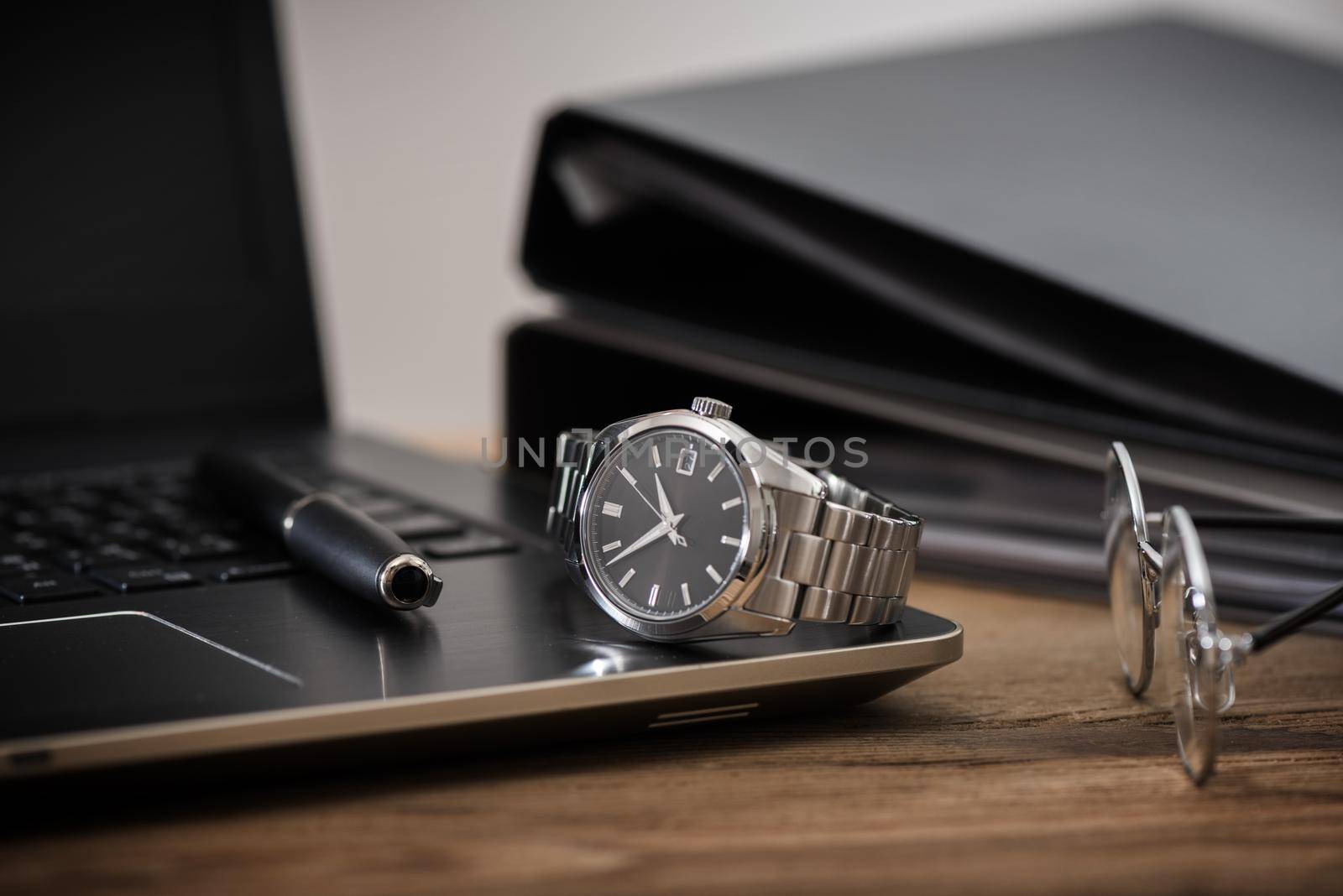 men's accessories, closeup at the luxury automatic wristwatch with black dial and stainless steel bracelet.