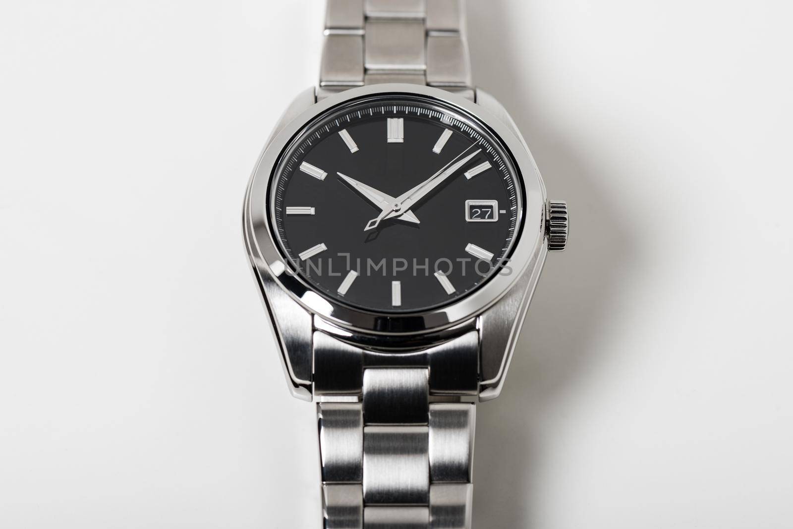 closeup luxury automatic wristwatch for men with black dial and stainless steel bracelet. Watch isolated over white background